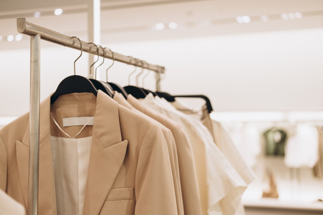 Women's Clothes in Beige Colors on Open Hangers in Store