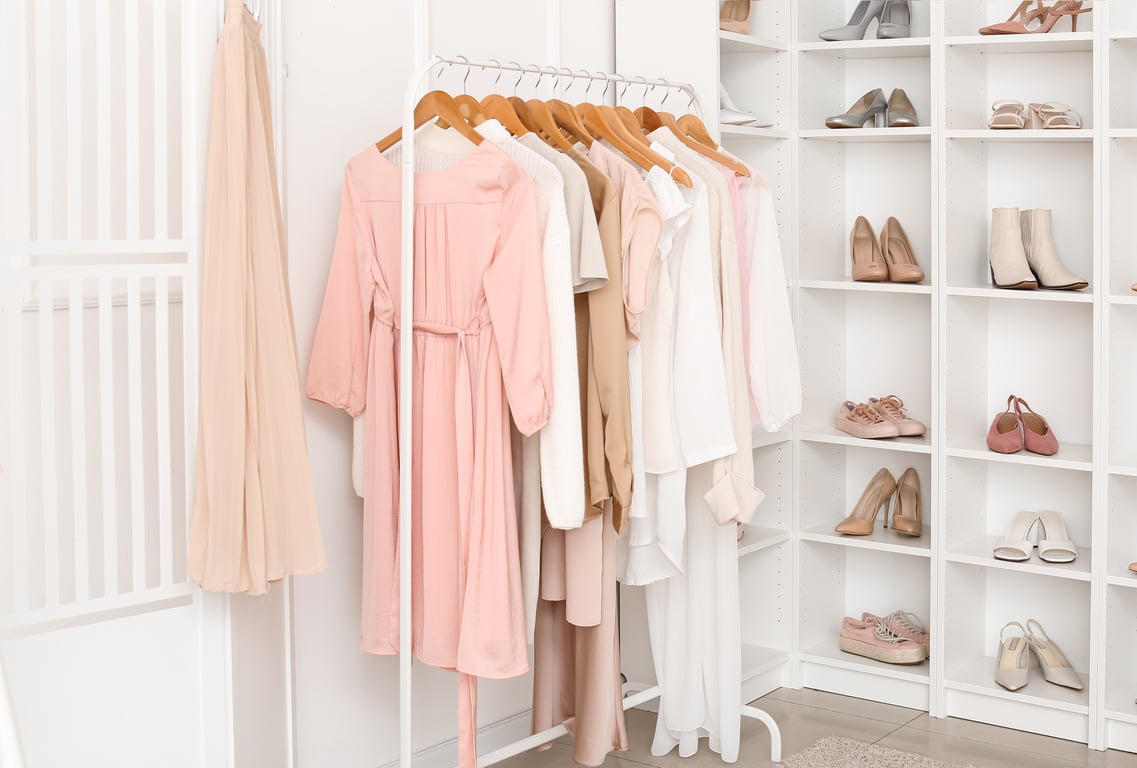 Photo d'un dressing et d'un portant de vêtements pour la prestation de tri du dressing. Les couleurs sont le rose, le beige, le blanc.
Les vêtements sont pour les femmes qui veulent apprendre à se mettre en valeur par leur silhouette.